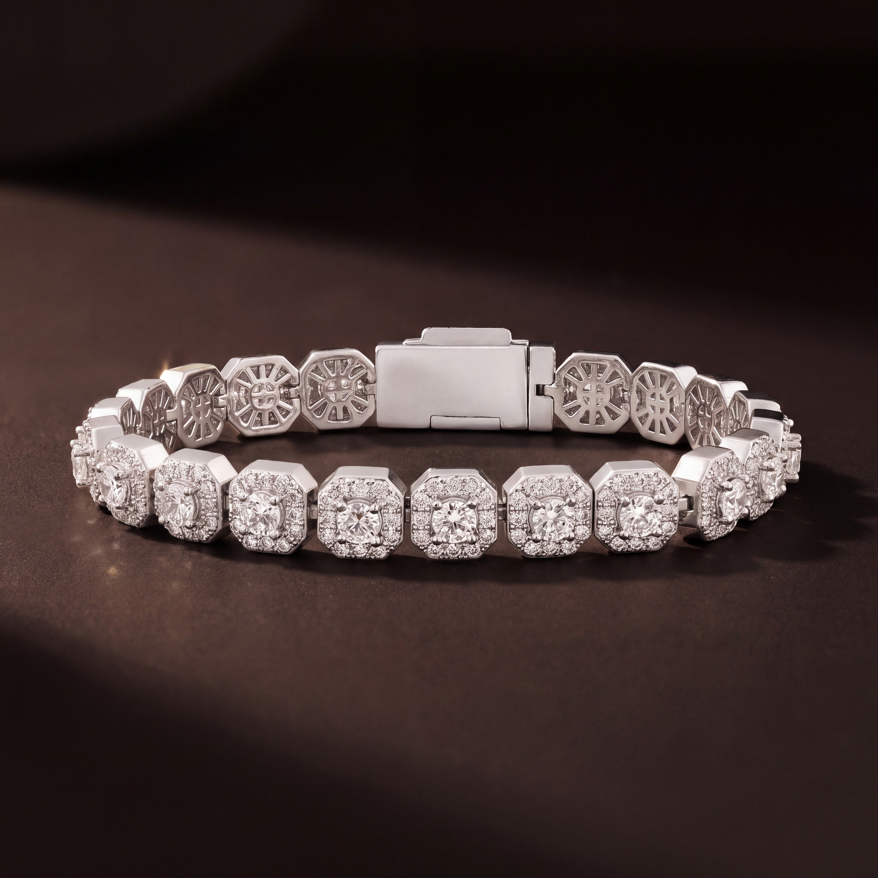 Iced cluster tennis bracelet standing coiled, showing the box clasp and open gallery backs